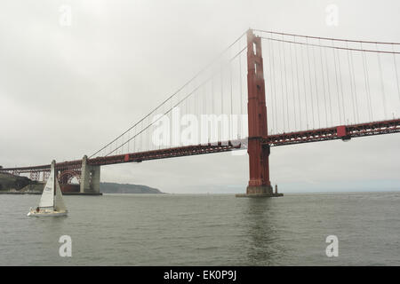 Grauen Himmel Advektion Nebel Ansicht von Bay Ferry, Yacht, die Richtung Süden Turm Golden Gate Bridge überqueren San Francisco Bay, USA Stockfoto