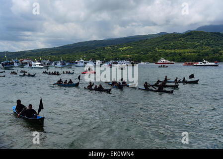 Larantuka, Indonesien. April 2015. Boote, die eine Seevasion beginnen, um eine alte kleine Holzkiste mit einer Statue des Jesuskindes in den Küstengewässern in der Nähe der Tuan Menino Kapelle in Larantuka, Flores Island, Ost-Nusa Tenggara, Indonesien zu transportieren. Stockfoto