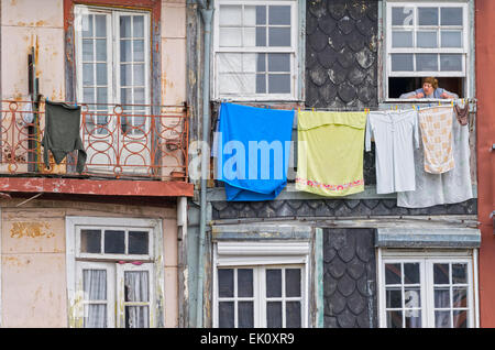 PORTUGAL-PORTO-STRAßE NOVA DE ALFANDEGA NEBEN DEM FLUSS DOURO LADY GERADE AUS EINEM FENSTER MIT WASCHEN HÄNGEN IN EINER ZEILE Stockfoto