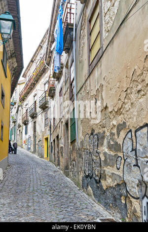 PORTUGAL-PORTO BRÖCKELNDE WÄNDE IN EINE ALTE STRAßE MIT WÄSCHE AUFHÄNGEN AUF EINEM BALKON Stockfoto