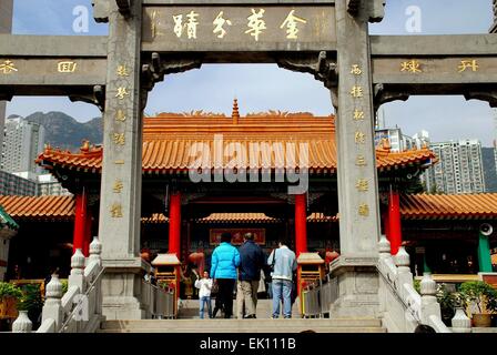 Hong Kong, China: Menschen durchlaufen eine große zeremonielle Tor eingeschrieben mit chinesischen Schriftzeichen auf der Wong Tai Sin Temple Stockfoto