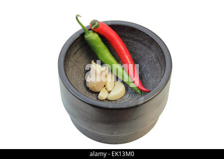 Ingwer, Knoblauch und Chili (einige der Grundzutaten in der thailändischen Küche) in einem Mörser isoliert auf weißem Hintergrund. Stockfoto