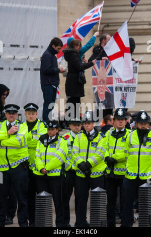 Whitehall, London, 4. April 2015. Wie PEGIDA UK eine schlecht besuchte Kundgebung am Whitehall hält, sind Resultate von Polizei gerufen, um gegen Demonstranten aus verschiedenen London antifaschistischen Bewegungen enthalten. Bild: Vollständig umgeben von einer Mauer von Polizisten zu ihrem eigenen Schutz, Welle PEGIDA-Rallye-Teilnehmer ihre Flaggen. Bildnachweis: Paul Davey/Alamy Live-Nachrichten Stockfoto