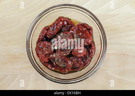 getrocknete Tomaten mit Olivenöl auf Holzuntergrund Stockfoto