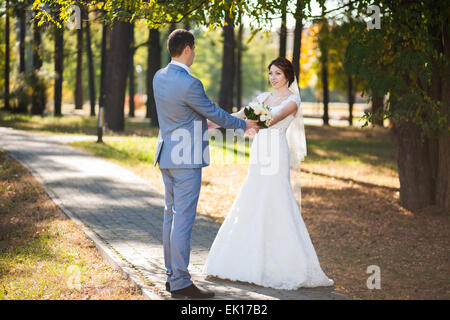 glückliche Braut, Bräutigam stehen im grünen Park, küssen, Lächeln, lachen, umarmen. Liebhaber in Hochzeitstag Stockfoto