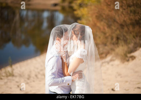 Braut und Bräutigam küssen am Strand, romantische Ehepaar Stockfoto