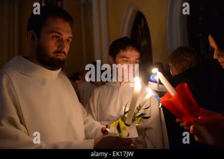 Moskau, Russland. 4. April 2015. Priester teilen Osterfeuer mit Gläubigen während der Ostergottesdienst in der Kathedrale der Unbefleckten Empfängnis in Moskau, Russland, 4. April 2015. © Pavel Bednyakov/Xinhua/Alamy Live-Nachrichten Stockfoto