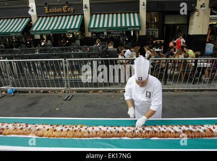 Buenos Aires, Argentinien. 4. April 2015. Ein Meister der Blätterteig Scheiben geflochten Osterbrot am Mai Avenue, Buenos Aires, Argentinien, am 4. April 2015. Laut lokalen Presseberichten hat geflochtene Osterbrot 150 m Länge und die Breite von 24 cm, das größte Brot überhaupt in Argentinien hergestellt wird. Das Brot soll in Scheiben für einen guten Zweck verkauft werden. © Alberto Raggio/Xinhua/Alamy Live-Nachrichten Stockfoto