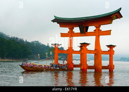 Boot nähert sich Torii Tor des Itsukushima-Schrein während Kangen-Sai Festival, Miyajima, Japan Stockfoto