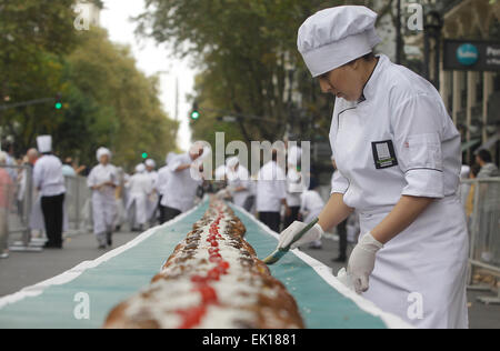 Buenos Aires, Argentinien. 4. April 2015. Ein Meister der Blätterteig Scheiben geflochten Osterbrot am Mai Avenue, Buenos Aires, Argentinien, am 4. April 2015. Laut lokalen Presseberichten hat geflochtene Osterbrot 150 m Länge und die Breite von 24 cm, das größte Brot überhaupt in Argentinien hergestellt wird. Das Brot soll in Scheiben für einen guten Zweck verkauft werden. © Alberto Raggio/Xinhua/Alamy Live-Nachrichten Stockfoto