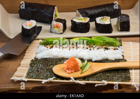 Maki Sushi machen Brötchen mit Lachs, Avocado und Gurke Stockfoto