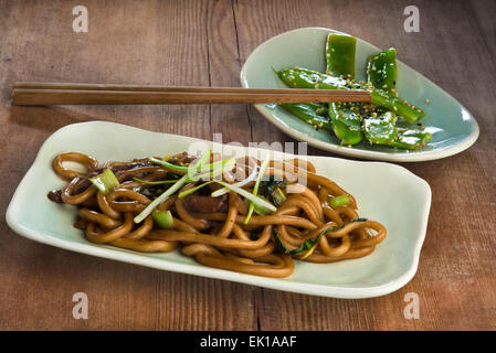 Rühren Sie gebratene Udon-Nudeln mit Bok Choy, Austernpilze, Frühlingszwiebeln und grüne Bohnen gebraten mit Knoblauch und Sesam. Stockfoto