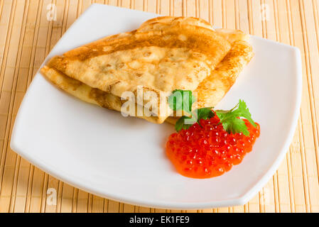 Pfannkuchen mit Kaviar auf einer weißen quadratischen Platte Stockfoto