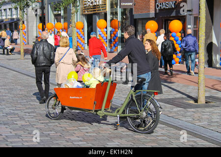 Dordrecht, Niederlande - 28 September: junge Eltern tragen Kinder im Fahrrad Kinderwagen durch feierliche Straße am 28. September 2013 in Dordrecht, Niederlande Stockfoto