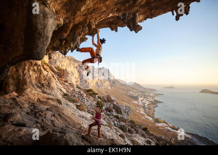 Junge Frau Vorstieg in Höhle mit schöner Aussicht im Hintergrund Stockfoto