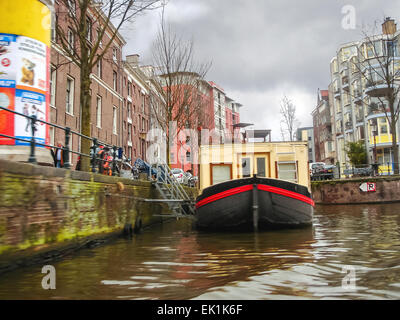 Amsterdam, Niederlande - 18 Februar 2012: Hausboot auf dem Kanal in Amsterdam. Viele Niederländer lieber auf Hausbooten zu leben Stockfoto