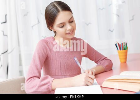 Teenager-Mädchen in ihr Heft schreiben Stockfoto