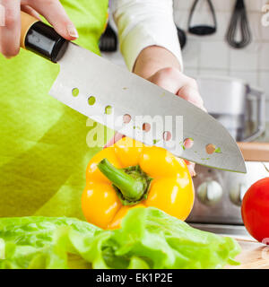 Frauenhand schneiden frische Paprika in der Küche Stockfoto