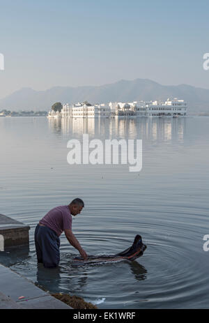 Indischer Mann wäscht Kleidung im Pichola-See, Udaipur, Rajasthan, Indien Stockfoto