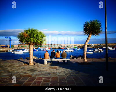 Touristen, die Ruhe, sitzen auf Bank auf der Promenade Süd Küste Strand Teneriffa Insel Kanaren Spanien Stockfoto