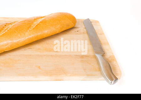 Laib frisch gebackenes Brot mit einem Messer auf ein Schneidebrett Stockfoto