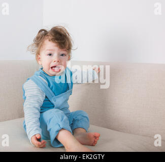 1 Jahr alt jungen Weinen beim Sitzen auf dem Sofa. Stockfoto