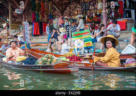 Thai-Frauen verkaufen Obst von einem Boot auf dem schwimmenden Markt in Damnoen Saduak. Der schwimmende Markt ist eine wichtige touristische Attraktion. Stockfoto