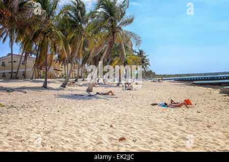 Menschen, die im Sand des tropischen Strand mit Palmen und einem blauen Ozean auf Maria la Gorda, Kuba Stockfoto