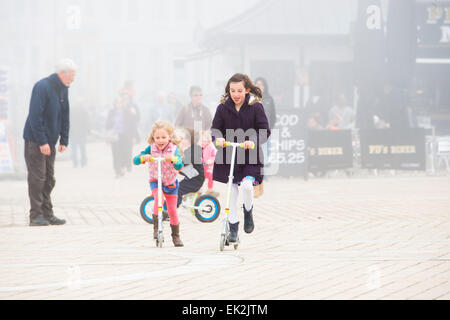 Aberystwyth, Wales, UK. 6. April 2015. Nach einem hellen Start überfahren Meer Nebel Aberystwyth am Oster-Montagmorgen. Trotz der kalten nebligen Luft Rennen Kinder im Urlaub ihre Roller entlang der Promenade und der Seebrücke trotzdem, das warme Wetter wird voraussichtlich für die nächsten Tage, vor allem im Westen des Vereinigten Königreichs, mit Temperaturen bis 19-20 º c stellenweise Kredit bleiben: Keith Morris/Alamy Live-Nachrichten Stockfoto