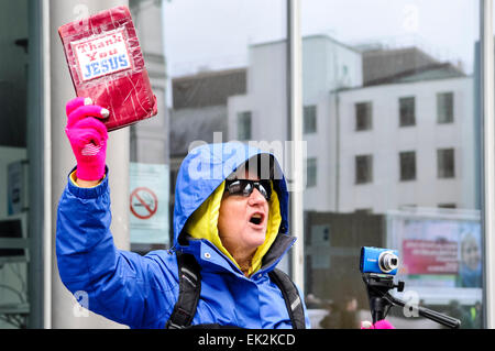 Belfast, Nordirland, 1. Februar 2014 - eine christliche Frau entführt einen republikanischen Protest für den sozialen Wohnungsbau, erzählen die Teilnehmer "braucht man Iren zu stoppen, gegeneinander kämpfen und Kampf gegen Gott".  Die Demonstranten ignoriert weitgehend, ihre Verkündigung. Stockfoto