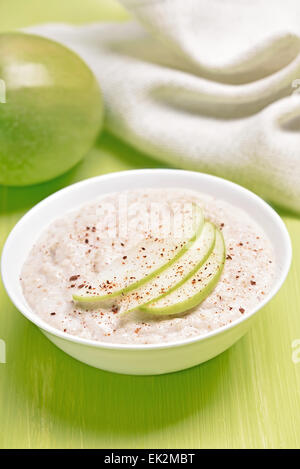 Haferflocken-Porridge mit Apfelstückchen und Zimt in einer Schüssel weiß Stockfoto