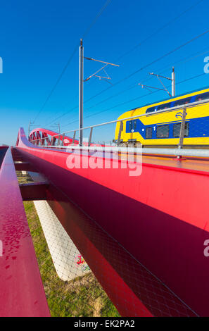 Zug vorbei die neue rote Eisenbahnbrücke über die IJssel in den Niederlanden Stockfoto