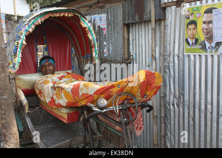 Ein Bangladeshi Obdachlose ein Nickerchen auf der Rikscha in Tongi in Dhaka, Bangladesch. Stockfoto