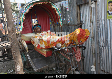 Ein Bangladeshi Obdachlose ein Nickerchen auf der Rikscha in Tongi in Dhaka, Bangladesch. Stockfoto