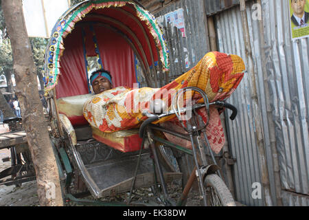 Ein Bangladeshi Obdachlose ein Nickerchen auf der Rikscha in Tongi in Dhaka, Bangladesch. Stockfoto