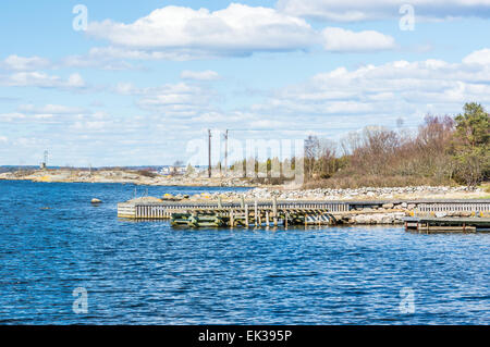 Stein und Holzbrücken in den Schären. Küste der Insel, blaues Wasser und bewölktem Himmel. Zeitigen Frühjahr. Keine Boote oder Menschen. Stockfoto