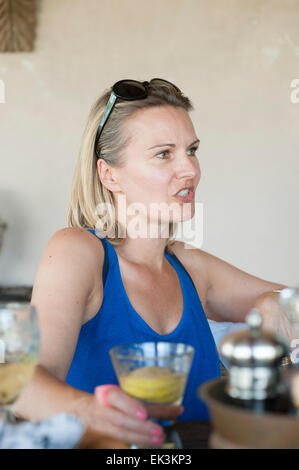 Eine Frau mittleren Alters genießt einen Drink im Urlaub Stockfoto