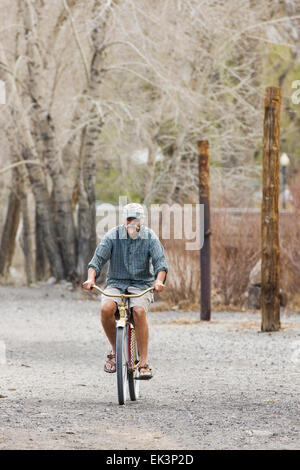 Einsame Radfahrer fährt auf dem kargen Land entlang Arkansas River im Besitz von Union Pacific Railroad. Stockfoto