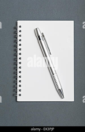 Bleistift auf einem Notebook auf grauem Hintergrund isoliert. Stockfoto