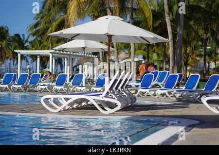 Lounge Stühle um einen Pool in einem tropischen resort Stockfoto