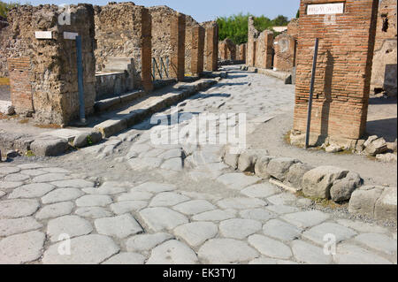 Römische Ruinen in Pompei, Italien. Spurrillen in den gepflasterten Straßen Via Consolare und Via Delle Terme. Stockfoto