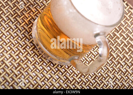 Glas frisches Bier mit Kappe aus Schaumstoff Stockfoto