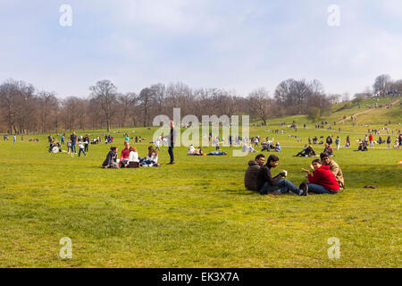 Londoner und Touristen genießen den Nachmittag Sonnenschein und warme Temperaturen im geschäftigen Greenwich Park. Stockfoto