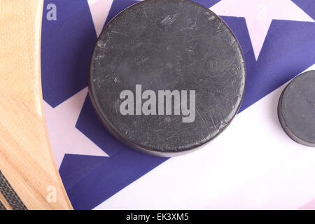 Hockey-Ausrüstung, einschließlich einen Stock und Puck auf eine amerikanische Flagge, eine patriotische amerikanische Sportart abzuleiten. Stockfoto