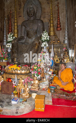 Buddhistischer Mönch sitzt im Wat Na Phra Mane Tempel von Ayutthaya Thailand trägt die traditionelle Orange gefärbte Gewand Stockfoto