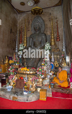 Buddhistischer Mönch sitzt im Wat Na Phra Mane Tempel von Ayutthaya Thailand trägt die traditionelle Orange gefärbte Gewand Stockfoto