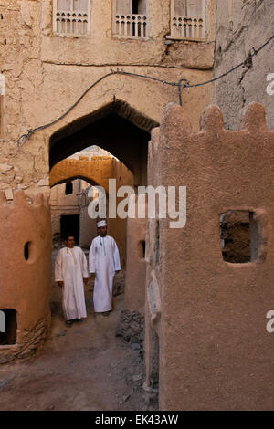 Männer in Dischdaschas Wandern im alten Teil des Al-Hamra, Oman Stockfoto