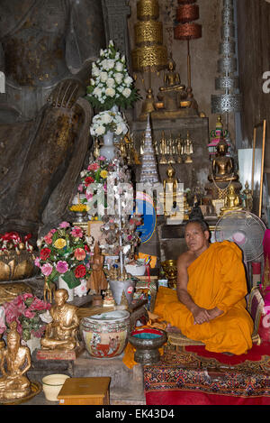 Buddhistischer Mönch sitzt im Wat Na Phra Mane Tempel von Ayutthaya Thailand trägt die traditionelle Orange gefärbte Gewand Stockfoto