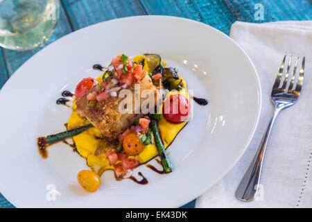 Knuspriger Schweinebauch auf Kabocha Squash-Püree mit Tomaten und Spargel, garniert mit Pico de gallo Stockfoto
