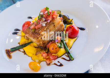 Knuspriger Schweinebauch auf Kabocha Squash-Püree mit Tomaten und Spargel, garniert mit Pico de gallo Stockfoto